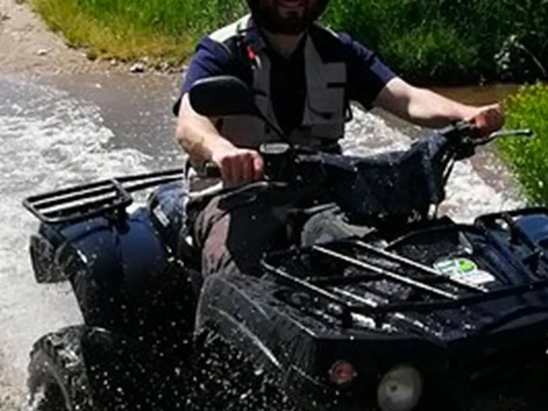 Un pilota Garda Adventure guada un torrente in quad